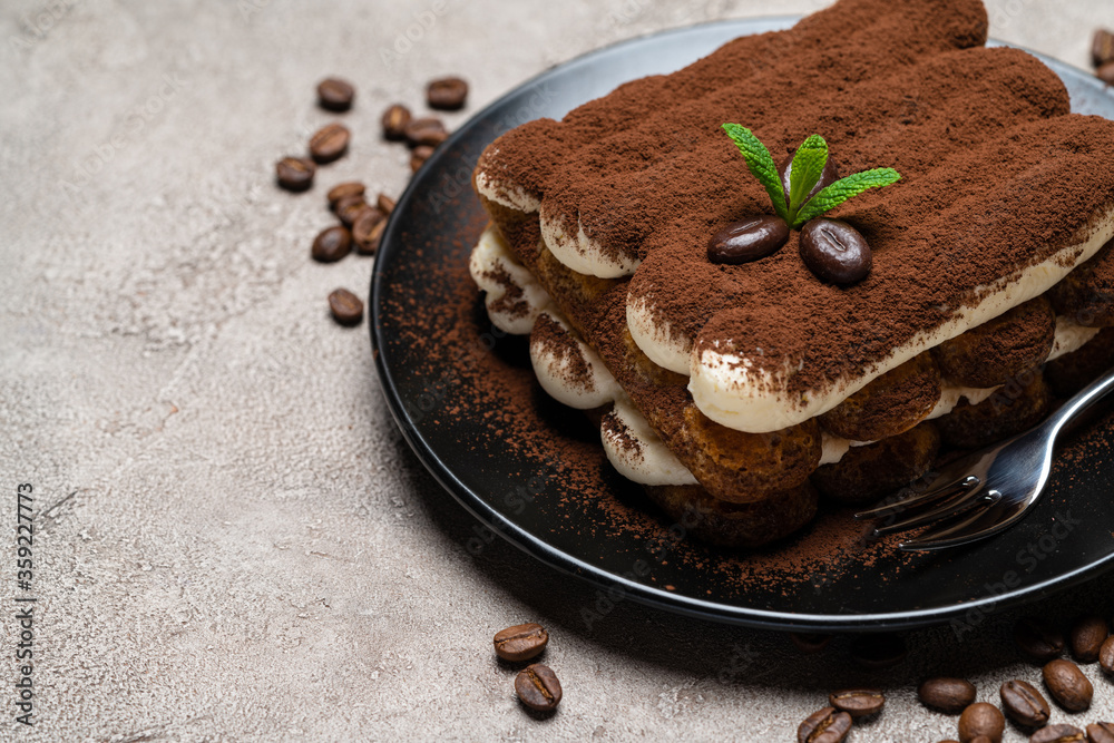 Classic tiramisu dessert on ceramic plate on concrete background Classic tiramisu dessert on ceramic plate on concrete background