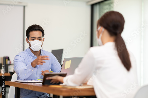 Business man and woman wearing face mask meeting and work together