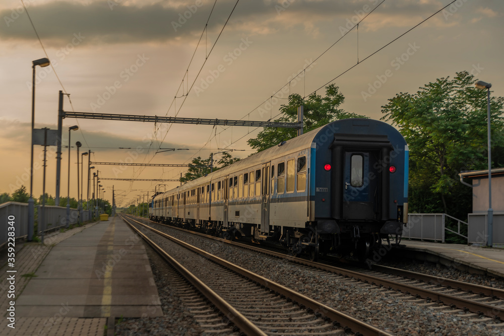 Electric blue engine and coaches on fast railway in south of Moravia