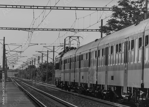 Black and white view of lectric blue engine and coaches on fast railway