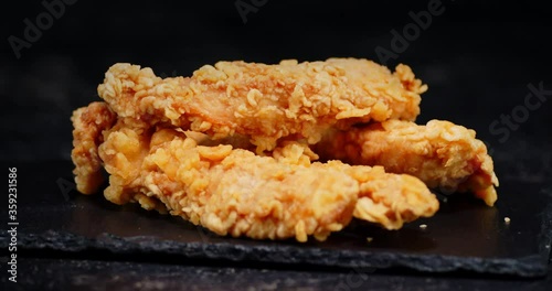 A pile of chicken strips on a stone Board rotates slowly.