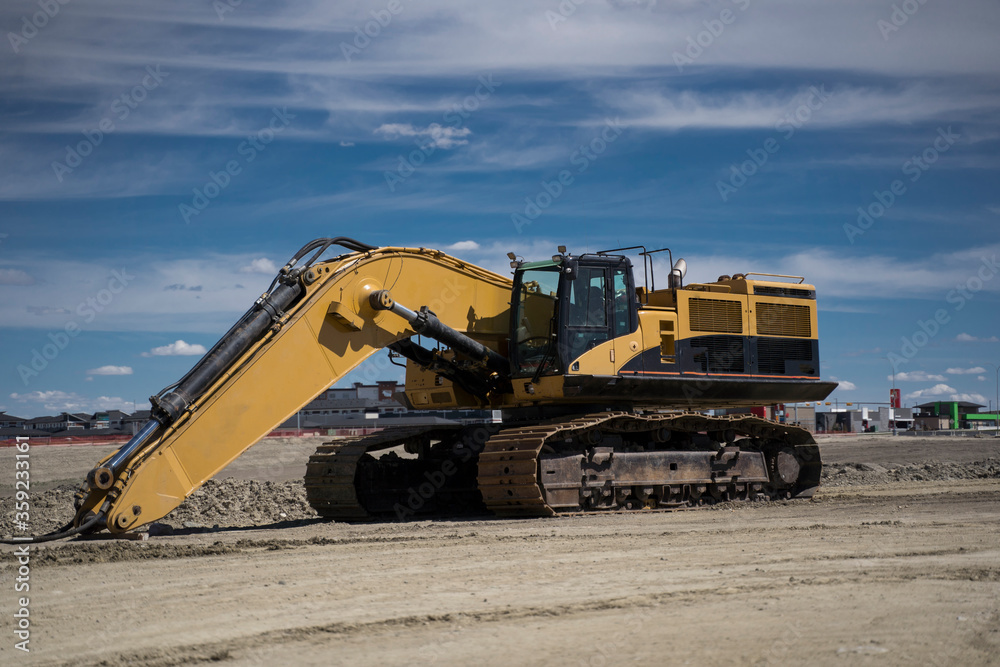 A large excavator sits in an urban development as this piece of machinery is assembled and requires maintenance. A large excavator sits in an urban development as this piece of machinery is assembled and requires maintenance.