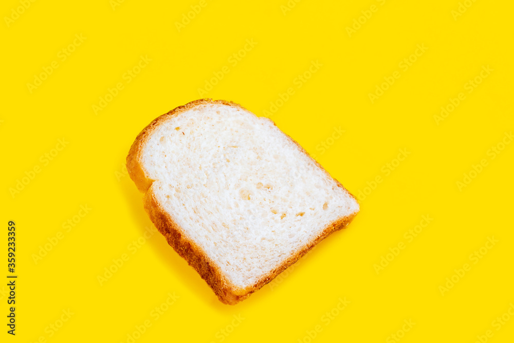 Close up photo of fresh baked toast bread on yellow background. Top view. Bread for breakfast.
