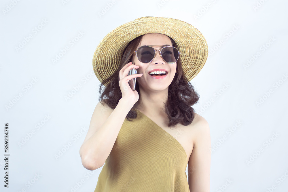 Asian woman talking on mobile phone and standing on white background