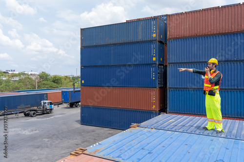 new normal concept.inspector engineer or project engineer wear helmet and use walkie talkie to contact the factory team or container yard.Remote execution to prevent Coronavirus infection
