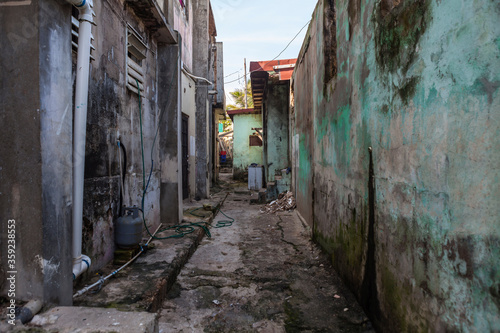 Grungy narrow dangerous looking back alley in Latin America. © trekandphoto