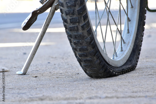 Closeup view of bicycle flat tire on pavement.