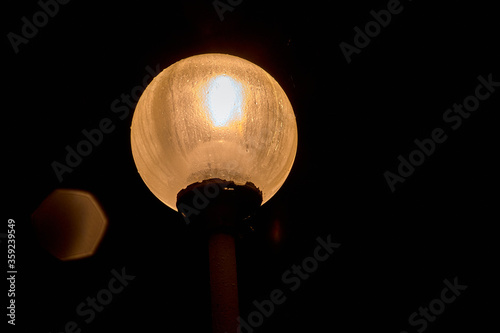 glowing round a lamppost in the night sky next to the glowing moths