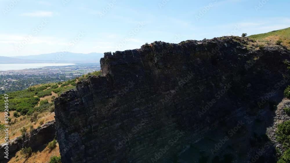 Looking at a shear cliff then ascend to reveal a view of a wide valley heavily populated Looking at a shear cliff then ascend to reveal a view of a wide valley heavily populated