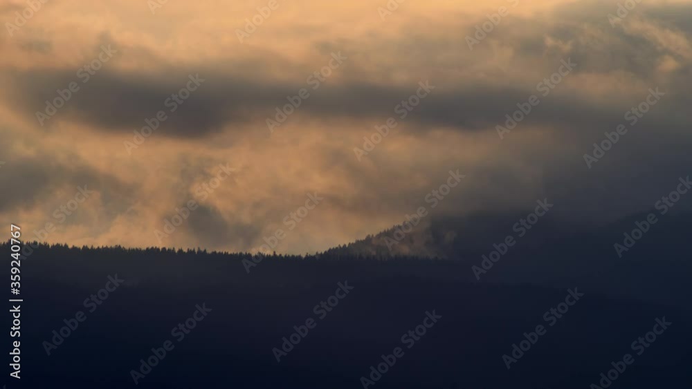 Clouds over the dark landscape of North Vancouver during sunset - wide Clouds over the dark landscape of North Vancouver during sunset - wide
