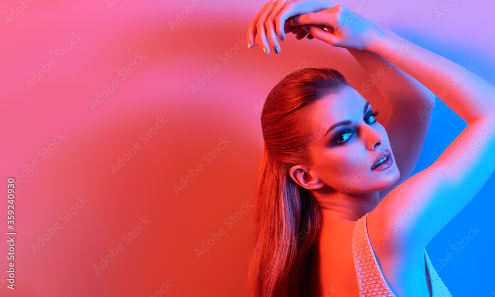 High Fashion. Woman in colorful neon light, make-up. Sexy girl, stylish hair, trendy makeup. Party disco neon style. Creative art beauty portrait, fashionable model face, bright make up