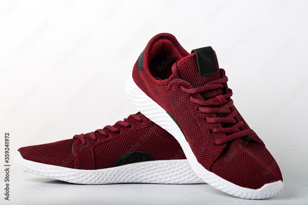High angle view on front part of modern red men's pair of sneakers for running. Close up shot on white background. High angle view on front part of modern red men's pair of sneakers for running. Close up shot on white background.