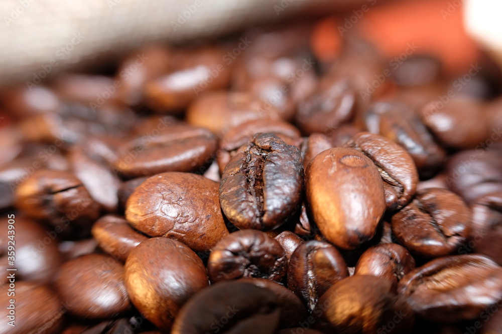 Naklejka premium bliska ziaren kawy i makro ziaren kawy na tle tabeli drewna