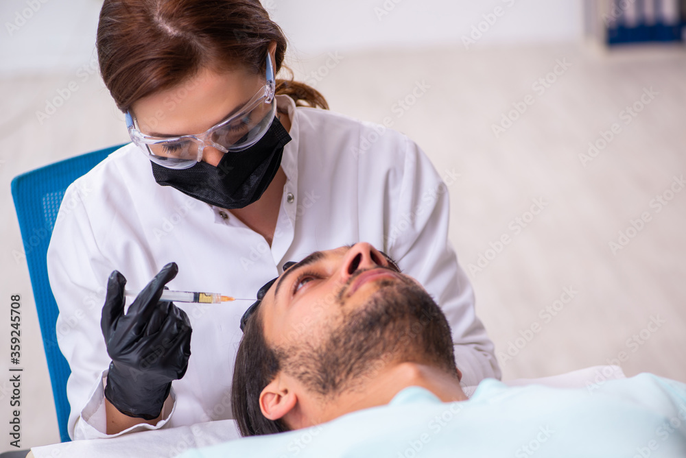 Fototapeta premium Young man visiting female beautician in hair transplantation con