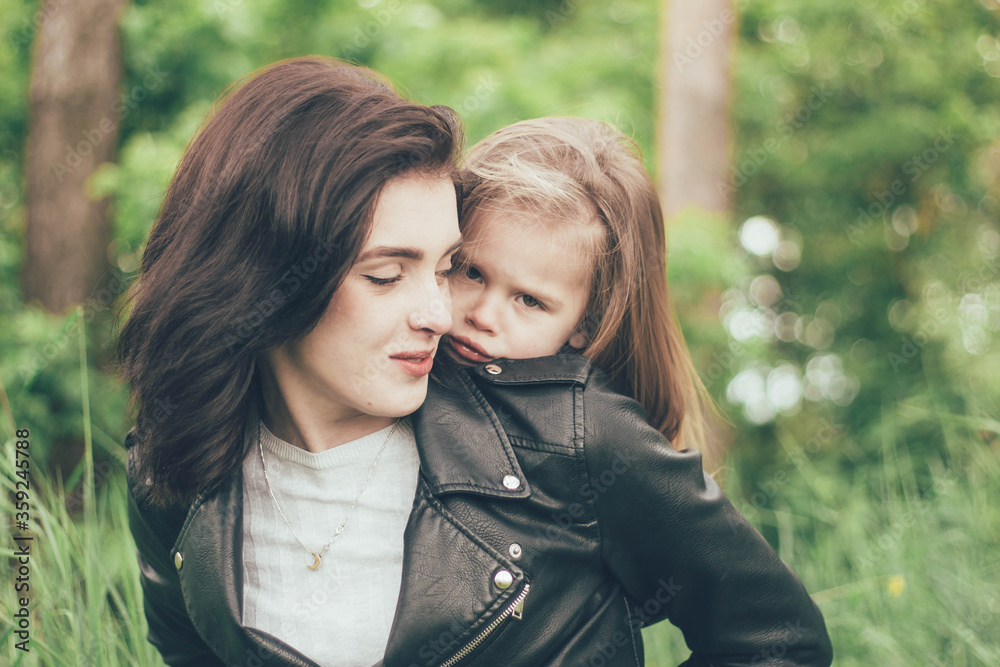 The girl is hiding behind her mother, the girl hugs her mother
The girl is hiding behind her mother, the girl hugs her mother