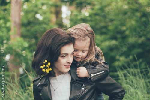  Girl with flowers hugs mom in nature