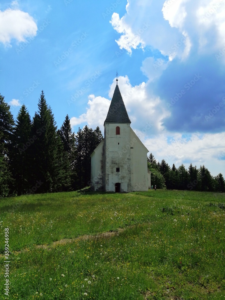 church on the Areh, Slovenia, green meadow with forest