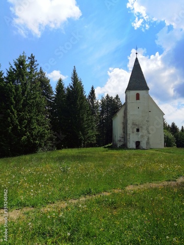 church on the Areh, Slovenia, green meadow with forest photo