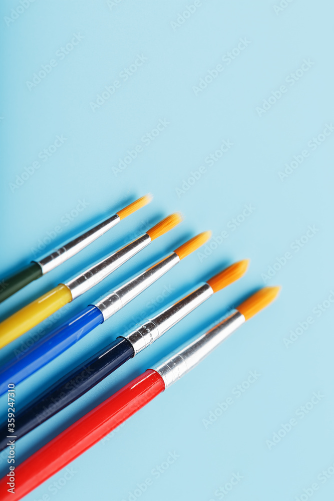 Multi-colored paint Brushes on a blue background. Multi-colored paint Brushes on a blue background.