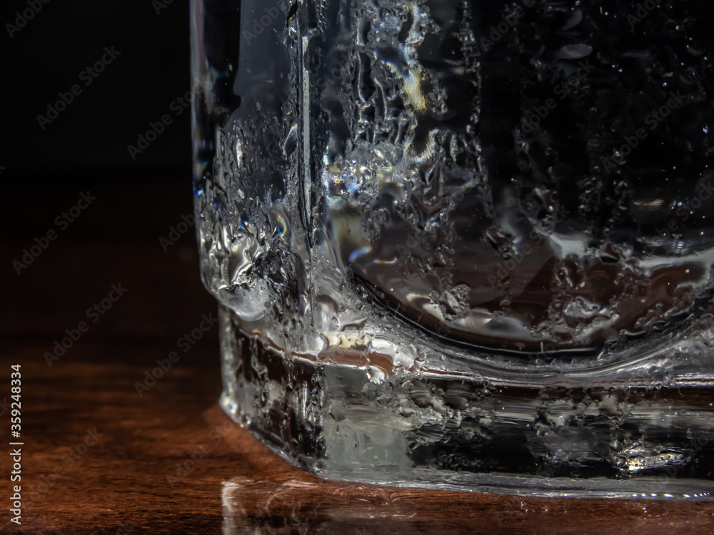 Cold water glass with droplets on it's body.