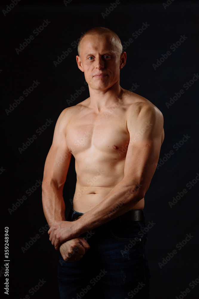 Muscular Model Young Man on Dark Background. Fashion Portrait of Strong Brutal Guy With Trendy Hairstyle. Sexy Naked Torso, Six Pack Abs. Male Flexing His Muscles. Sport Workout Bodybuilding Concept.