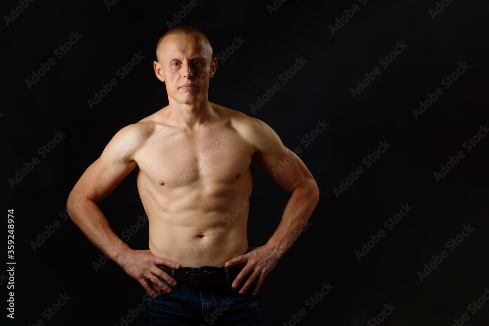 Strong Athletic Man Fitness Model. Isolated On Black Background With Copy Space Strong Athletic Man Fitness Model. Isolated On Black Background With Copy Space