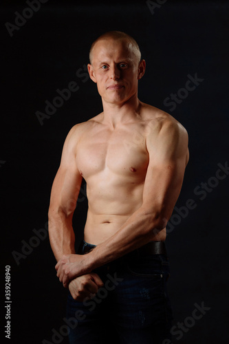 Muscular Model Young Man on Dark Background. Fashion Portrait of Strong Brutal Guy With Trendy Hairstyle. Sexy Naked Torso  Six Pack Abs. Male Flexing His Muscles. Sport Workout Bodybuilding Concept.