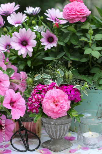 Gartendekoration mit Sommerblumen in Pink und Windlicht