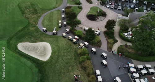 Drone video following a long row of golf carts driving along a concrete path before a golf tournament in Maryland photo