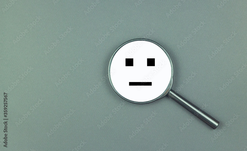 Fototapeta premium Neutral smile icon on a magnifying glass.