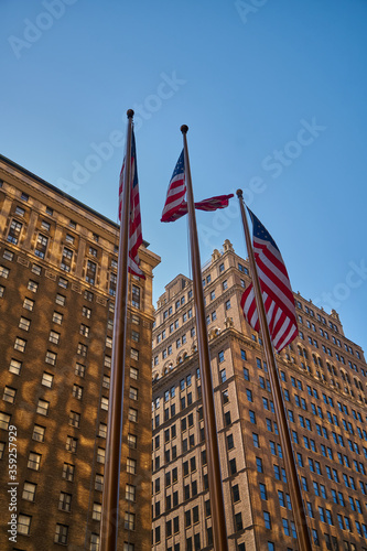 The American flag on the background of skyscrapers of New York city at the Manhattan, Times Square, USA at hot summer day