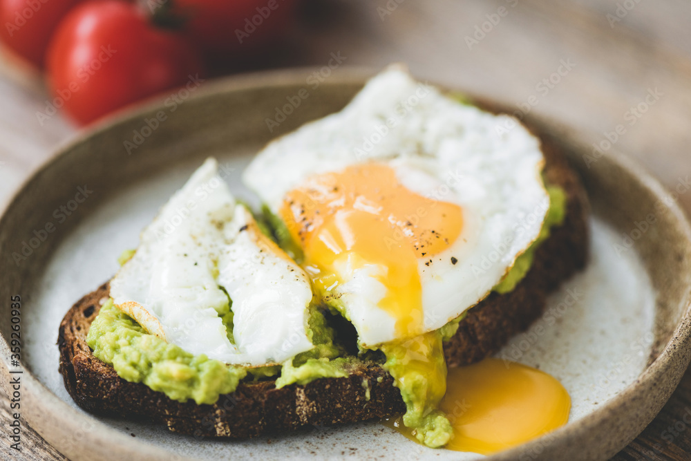 Toast with avocado and fried egg on plate. Healthy breakfast lunch or snack food Toast with avocado and fried egg on plate. Healthy breakfast lunch or snack food