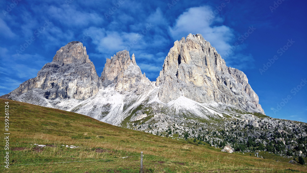 Trentino Alto - Adige, Italy - 06/15/2020: cenic alpine place with magical Dolomites mountains in background, amazing clouds and blue sky  in Trentino Alto Adige region, Italy, Europe