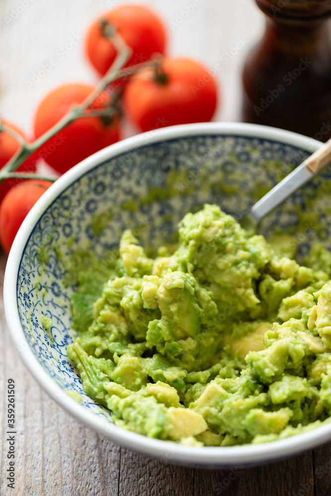 Mashed avocado in bowl. Chunky guacamole sauce Mashed avocado in bowl. Chunky guacamole sauce