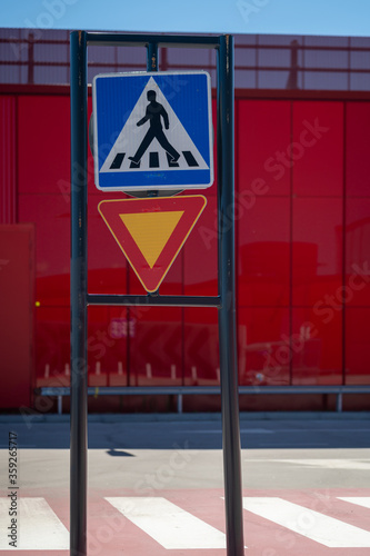 European style give way/yield and pedestrian crossing traffic signs on the parking lot.