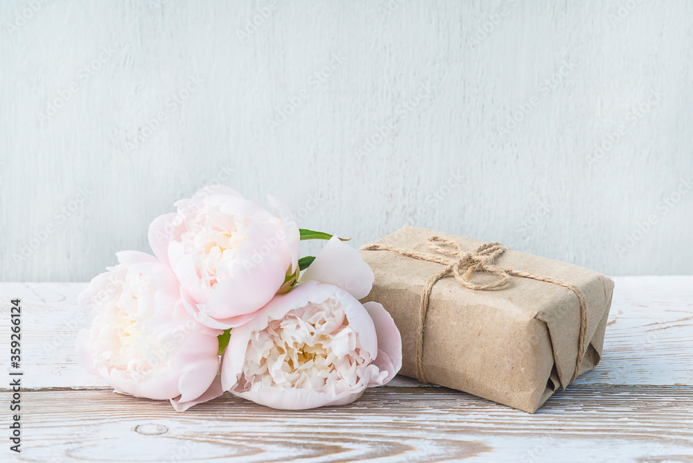 Romantic greeting card. Handmade gift box and white peonies on white paint wooden background. Space for text Romantic greeting card. Handmade gift box and white peonies on white paint wooden background. Space for text
