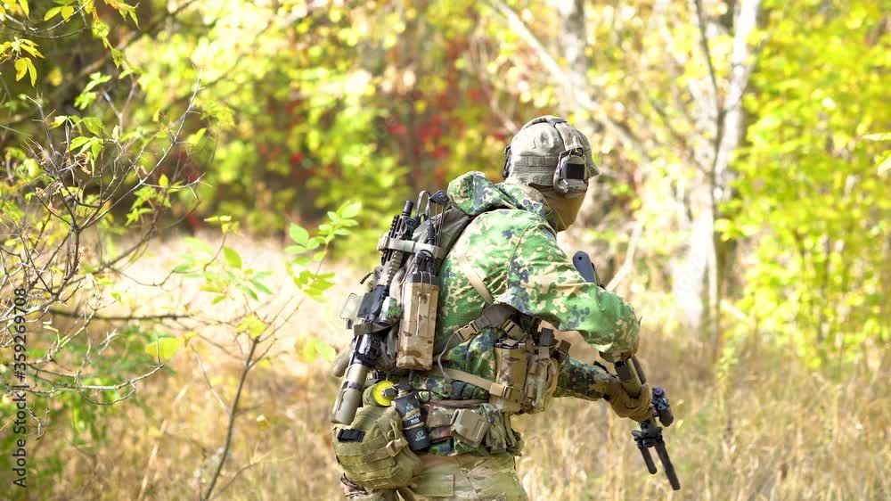 Military man stand up and go. Airsoft man with optical sight gun. Soldier hidden in forest, Military man stand up and go. Airsoft man with optical sight gun. Soldier hidden in forest,