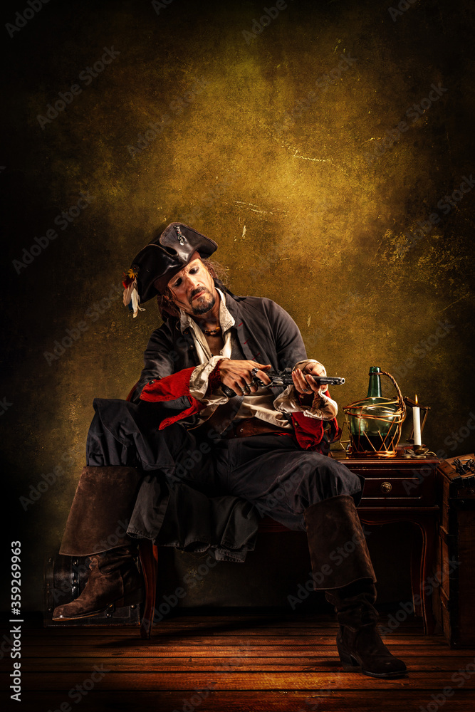 Naklejka premium Portrait of a pirate cleaning his musket gun, sitting in a tavern
