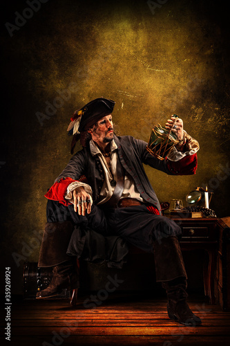Fotografie Portrait of a pirate drinking rum, sitting in a tavern