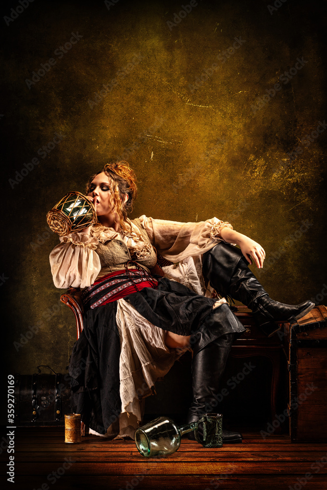 Portrait of a cheerful girl drinking rum in a tavern