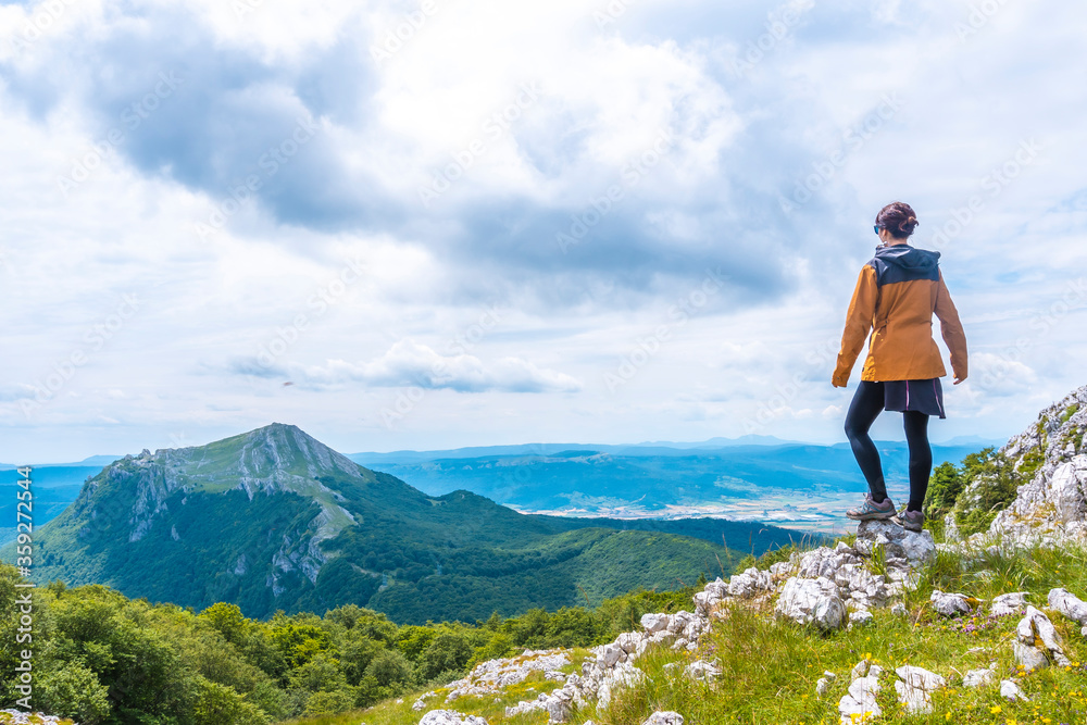 Mount Aizkorri 1523 meters, the highest in Guipuzcoa. Basque Country. A young woman with a yellow jacket up on top. Ascent through San Adrian and return through the Oltza fields
