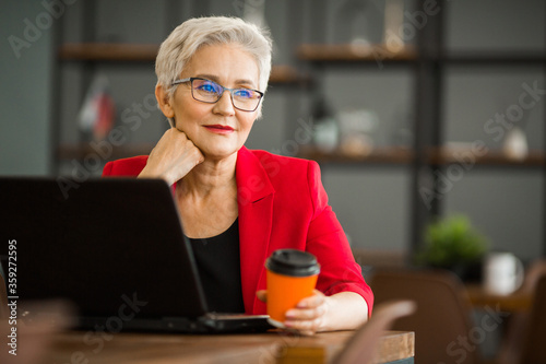 portrait of a beautiful adult woman in suit with laptop