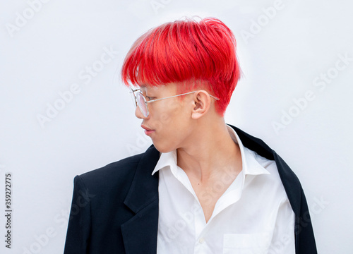 Portrait of a man with bright colored flying hair, all shades of red,purple. Hair coloring.Hair fluttering in the wind. Teen age with short hair. Professional coloring.