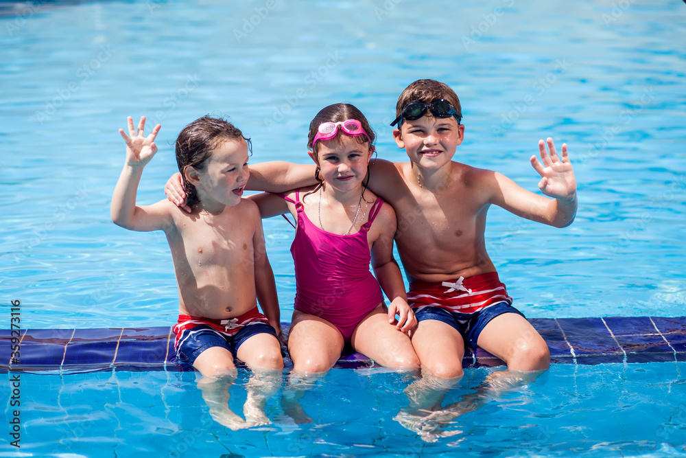 Kids playing in the swimming pool. Childhood, summer and vacation concept Kids playing in the swimming pool. Childhood, summer and vacation concept