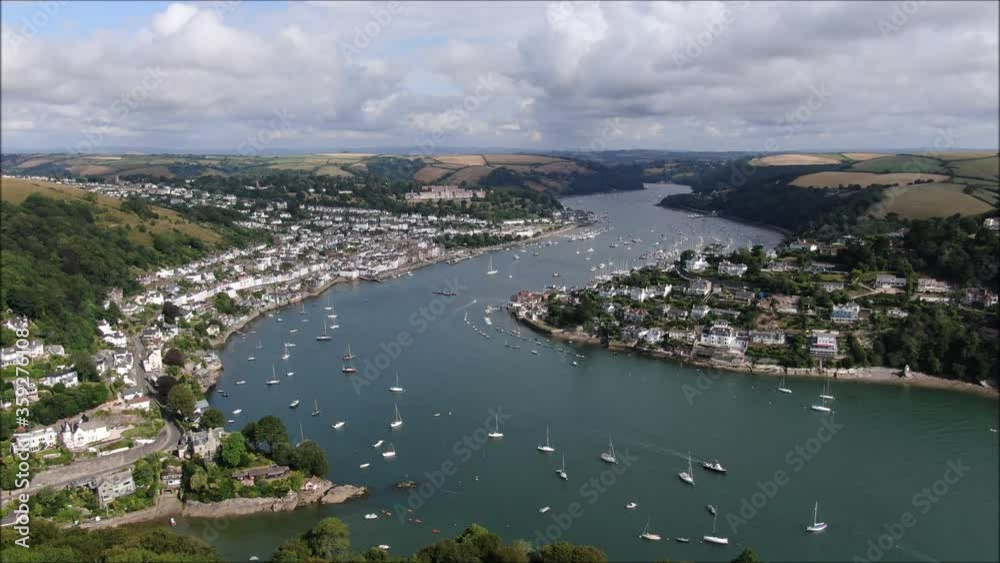 Descending drone shot over Dartmouth and River Dart. Shows river dart and descends to trees. Traditional holiday town. Regatta. Descending drone shot over Dartmouth and River Dart. Shows river dart and descends to trees. Traditional holiday town. Regatta.