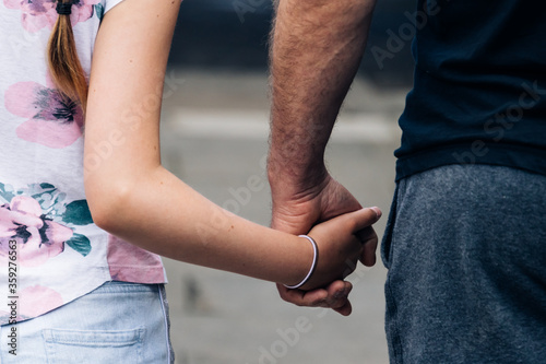 Young girl holding her father's hand