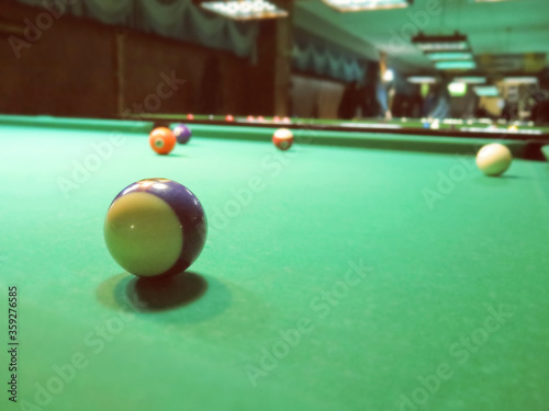 billiards, billiard balls on the table in the interior of the billiard game hall interior. Abstract blurred vintage image.