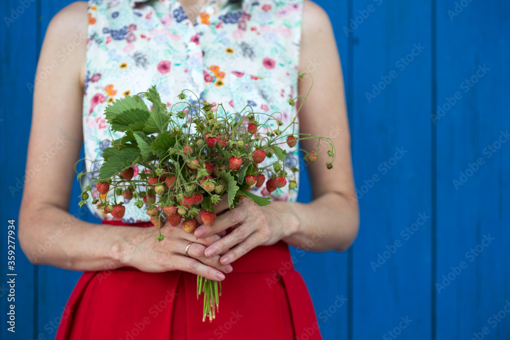 girl holding a bush of wild strawberries