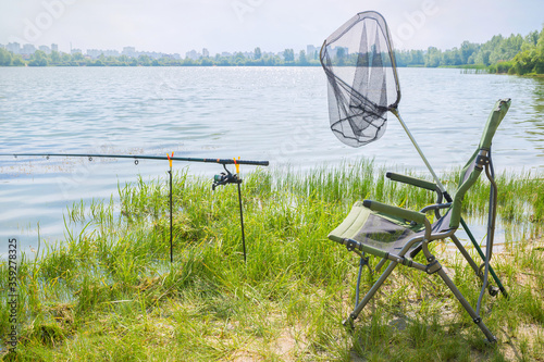 Fishing concept. Fishing tackle by the lake on a sunny day.