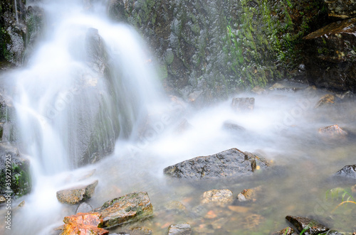 small beautiful fresh water mountainn creek waterfall in summer